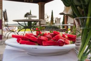 a plate of watermelon on a table with a vase at Agriturismo Il Felciaione in Massa Marittima