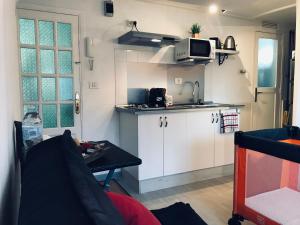 a small kitchen with white cabinets and a microwave at Studio 1 Hab in Pájara