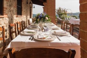 een lange tafel met borden en glazen erop bij Agriturismo Il Felciaione in Massa Marittima