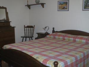a bedroom with a bed and a dresser and a chair at Fattoria Terra e Libertà in Contrada Maeggio