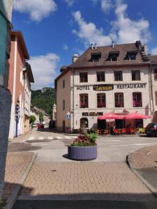 a building on the side of a street at Hôtel Le Lacuzon in Moirans-en-Montagne