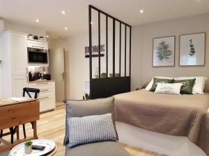 a bedroom with a large bed and a kitchen at La Bastido in Arles