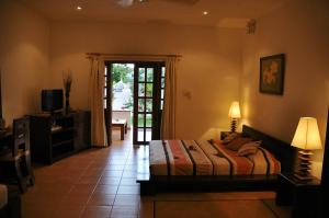 una camera con letto e porta di accesso a un patio di Britannia Hotel a Grand'Anse Praslin Altre 37 foto