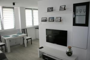 a living room with a flat screen tv and a table at Apartament Miedzianka in Polkowice