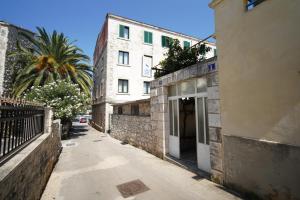 an alley with a building and a palm tree at Guesthouse Franko in Vela Luka