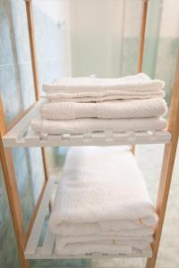 a stack of white towels on a shelf at B&B CA DEL SOLE in Serravalle Scrivia
