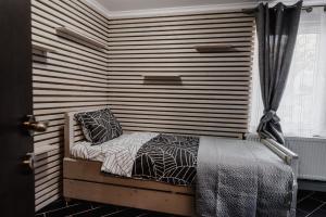 a small bed in a room with a striped wall at Casa Biriș in Cluj-Napoca