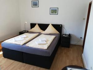 Bett in einem Zimmer mit zwei Kissen darauf in der Unterkunft Hotel Hohenzollernhof in Cuxhaven