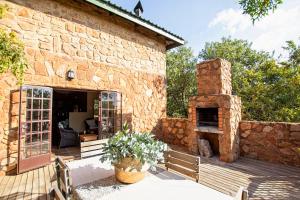 ein Steinhaus mit einem Steinofen auf einer Terrasse in der Unterkunft Milorho Lodge in Rietfontein