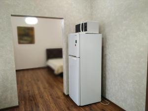 a refrigerator with a microwave on top of it in a room at Апартаменти в серці міста Лева in Lviv