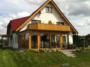 a house with a large deck on the side of it at Hotel Pension Neptun in Ueckeritz