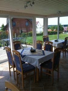 a table and chairs on a screened porch with a table and chairs at Hotel Pension Neptun in Ueckeritz