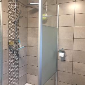 W łazience znajduje się prysznic ze szklanymi drzwiami. w obiekcie Les terrasses w mieście Malmedy
