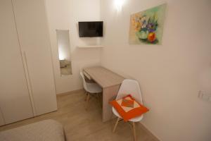 Habitación pequeña con escritorio y mesa con sillas. en ALL'ANTICO CAMPANILE, en Rovigo