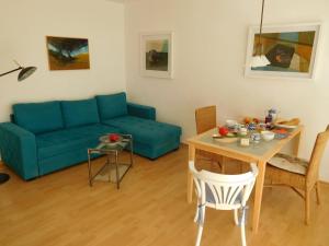 a living room with a blue couch and a table at Wohnung im Herzen von Ettlingen in Ettlingen