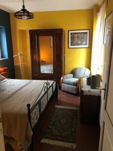 ein Schlafzimmer mit einem Bett, einem Sofa und einem Stuhl in der Unterkunft Noi Due Guest House - Fubine Monferrato in Fubine