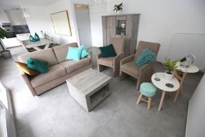 ein Wohnzimmer mit einem Sofa, Stühlen und einem Tisch in der Unterkunft Windekind V1 in Blankenberge