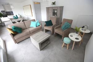 a living room with a couch and chairs and a table at Windekind V1 in Blankenberge