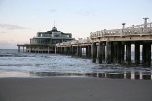 a pier on the beach next to the ocean at Windekind V1 in Blankenberge