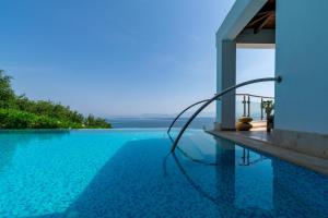 a pool with a view of the ocean from a house at Ionian Pearl Luxury Spa Villa in Mesongi