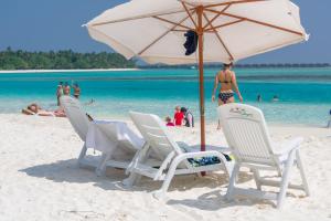 蒂夫斯的住宿－拉樹西亞酒店，海滩上的一组椅子和一把遮阳伞