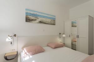 ein Schlafzimmer mit einem Bett mit zwei rosa Kissen in der Unterkunft Apartment Lana in Split