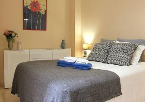 ラスパルマス・デ・グランカナリアにあるMarLenghi Apartmentのベッドルーム1室(青いタオル付きのベッド1台付)
