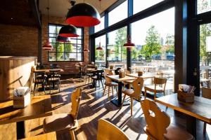 a restaurant with tables and chairs and large windows at RiKu HOTEL Pfullendorf in Pfullendorf