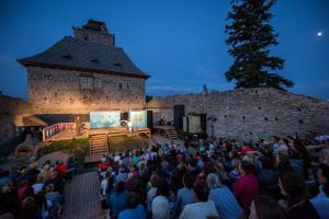 Una folla di persone che guarda un palco di fronte a un castello di Hostel Kašperské Hory a Kašperské Hory