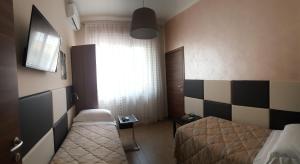 メザーニェにあるB&B Il Viandanteのベッド2台と窓が備わる小さな客室です。
