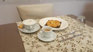 una mesa con dos tazas de café y pasteles. en B&B Il Viandante, en Mesagne