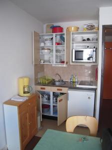 a small kitchen with white cabinets and a sink at Col de Rousset - App. 2 P in Rousset