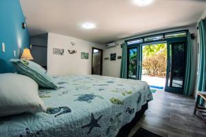 a bedroom with a bed with a blue comforter at The Isabela Beach House in Puerto Villamil