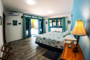 a bedroom with a bed and a table with a lamp at The Isabela Beach House in Puerto Villamil