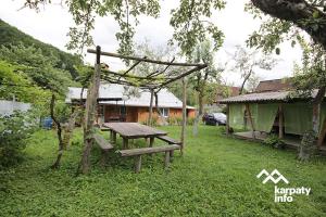 a picnic table and a bench in a yard at Садиба У Гайдука in Vizhenka