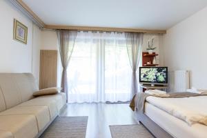 a living room with two beds and a large window at Apartment Natur in Bled