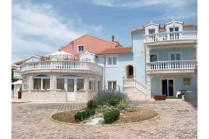 a large white house with a balcony on top of it at Apartments Villa Dalmatina in Vodice