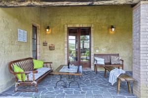 un patio con 2 sillas y una mesa en Appartamento Girasole - Agriturismo le Selvole, en Pomarance