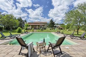 una piscina con sillas, una mesa y una casa en Appartamento Girasole - Agriturismo le Selvole, en Pomarance