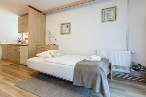 a bedroom with a white bed and a kitchen at Apartment Natur in Bled