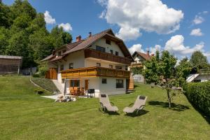 a house with two lounge chairs in the yard at Apartment Natur in Bled