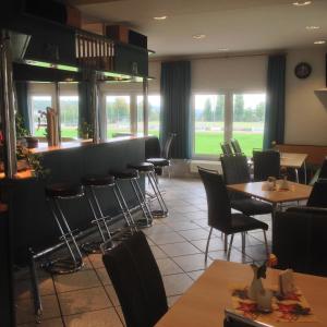 a restaurant with tables and chairs and a bar at Hotel Zum Sportforum in Blankenburg