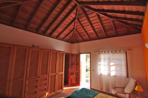 a bedroom with a wooden ceiling and a bed and a chair at Casa Tanausu in Todoque