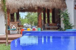 a house with a swimming pool and a thatch roof at Soho Boutique Holbox - Adults Only in Holbox Island