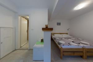 a bedroom with a bed in a white room at Room Nino in Skradin