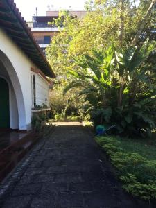 a brick walkway next to a house with trees at Muqui91 in Teresópolis