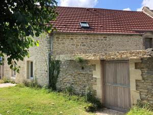 une ancienne maison en briques avec un garage dans l'établissement Gite Bord de Mer 80 m2, à Bernières-sur-Mer