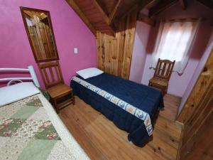 a small bedroom with a bed and two chairs at Pousada Canto de Pássaros in Painel