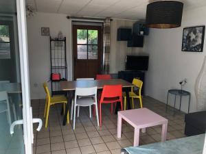 GITE BORD DE MER في Bernières-sur-Mer: غرفة طعام مع طاولة وكراسي ملونة