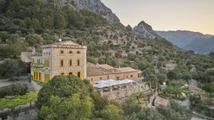 um grande edifício no meio de uma montanha em Agroturismo Alquería Blanca em Bunyola